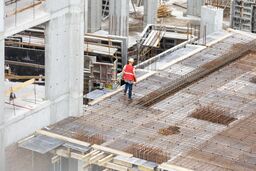 construction site workers working with cranes and excavators
