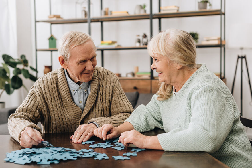 Elderly people with jigsaw in care home