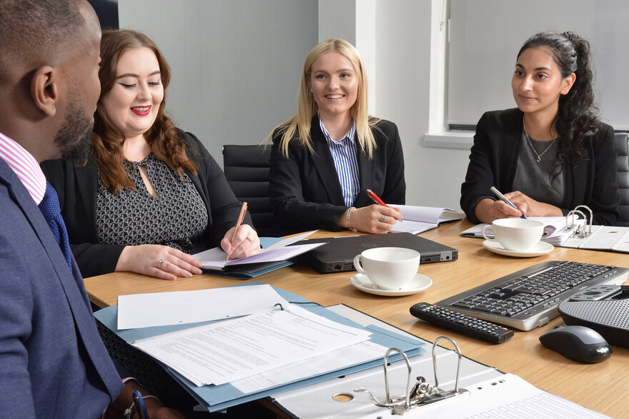 trainees sitting around table at meeting