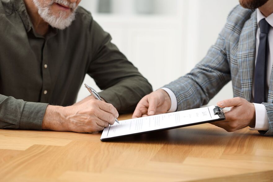 Senior Man Signing a Document 