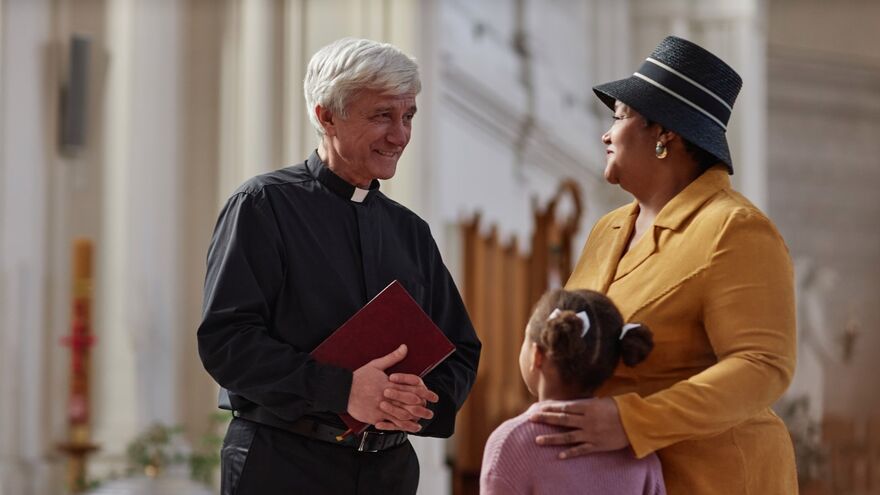 Priest talking with woman and child