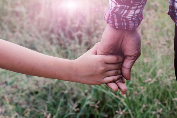 a father and child holding hands