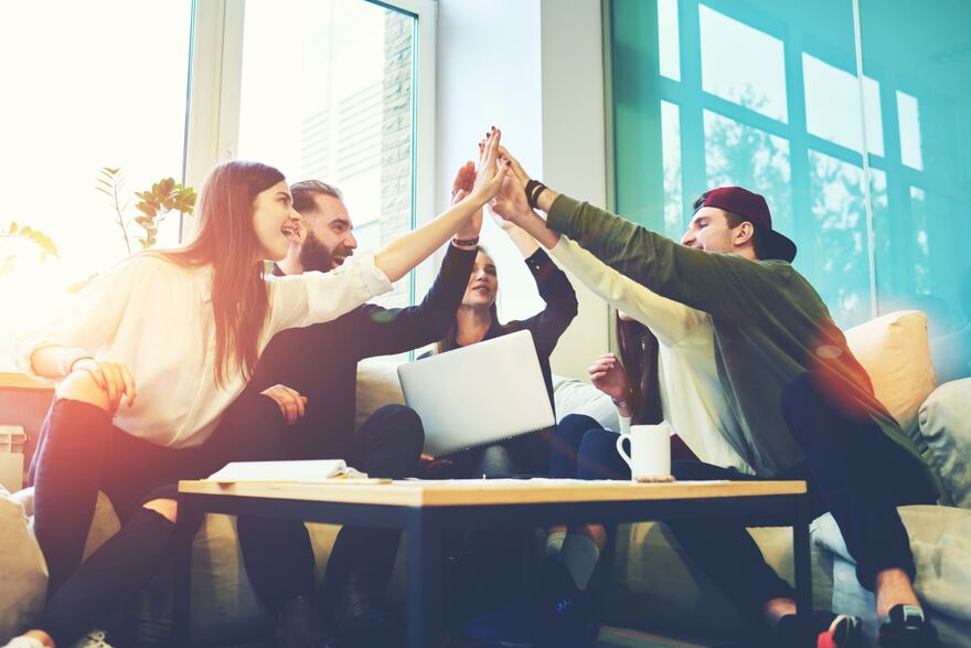 Group of young people celebrating in office
