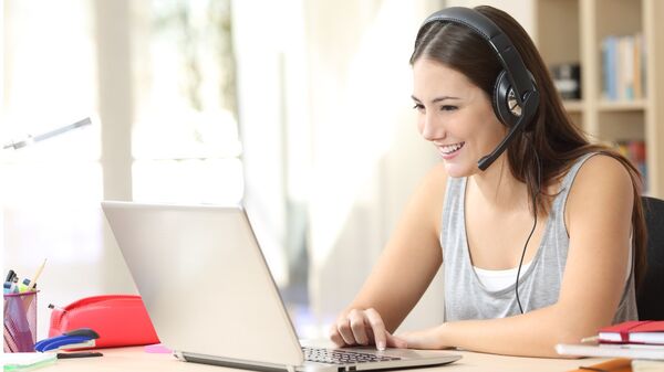 Woman sitting at laptop with headset
