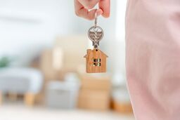 Moving house, relocation. Woman hold key house keychain in new apartment. move in new home