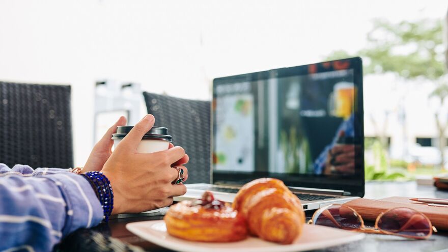 Person having breakfast at laptop