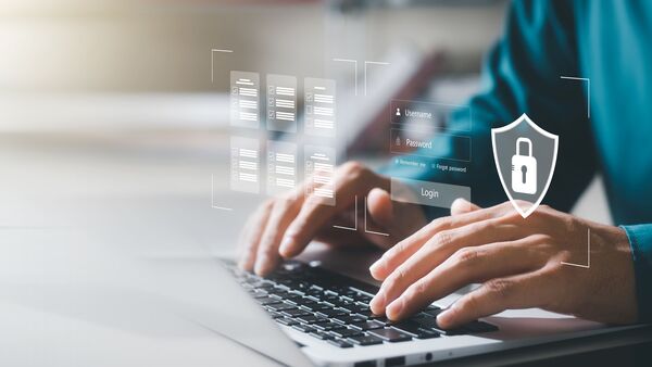 Man typing on laptop with data images