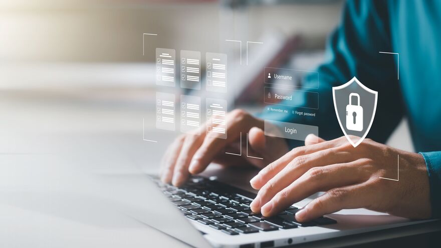 Man typing on laptop with data images