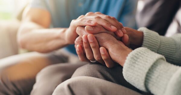 two people holding hands in support