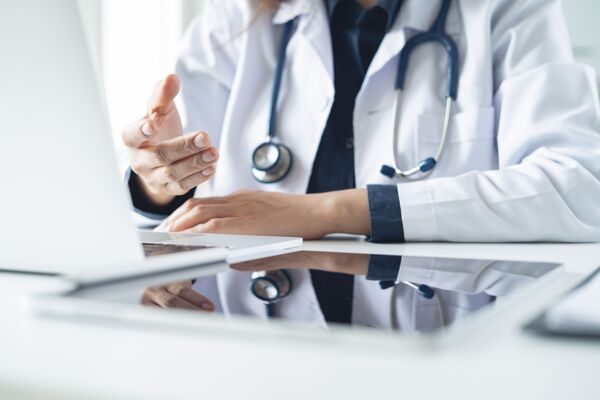 Telemedicine concept. Female doctor giving online consultation to patient via laptop computer at clinic office  for domestic health treatment. remote medical appointment, telehealth
