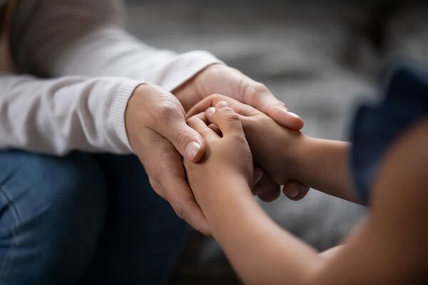 Adult holding child hands