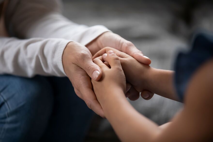 Adult holding child hands